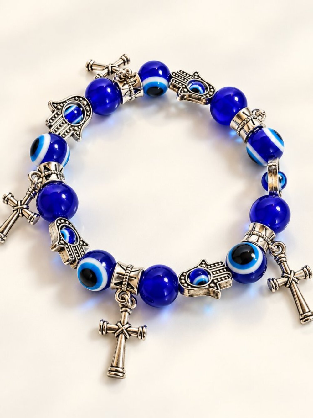 Blue evil eye bead stretch bracelet with silver-tone Hamsa hand and cross charms